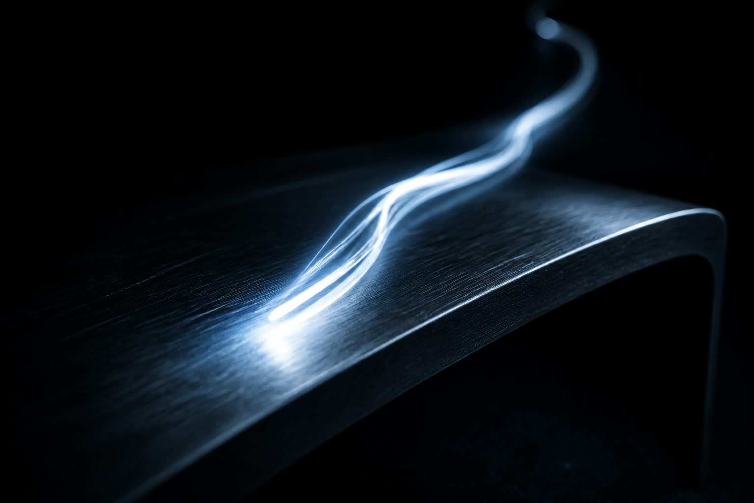 A compressed streak of light across black metal